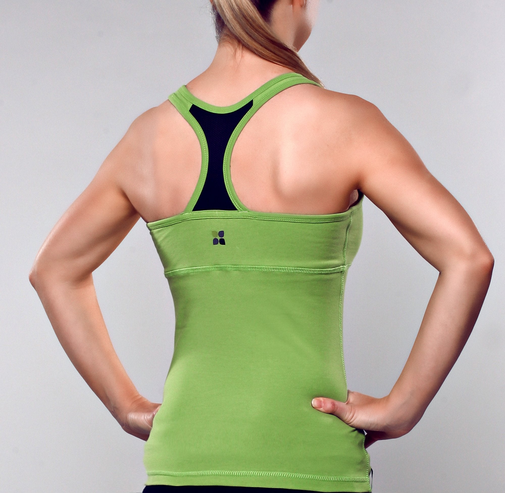 Model wearing apple green color racer back tank top with black contrast fabric at center back