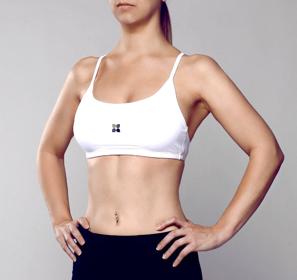 Front side view image of a woman wearing a white sport bra and black yoga pants