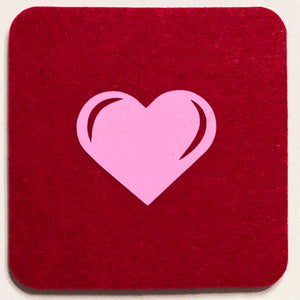 Closeup product image of a square shaped wool red drink coaster with a pink heart heat transfer design