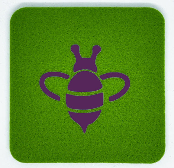 Closeup product image of a bright apple green square wool coaster with a purple bumble bee design centered on it