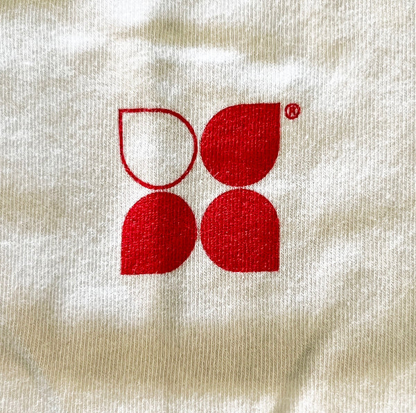 Closeup of a Yoga City logo in red printed on white knit fabric