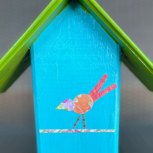 Closeup back view product image of aqua turquoise color decorative birdhouse with decoupaged whimsical bird design and green wooden roof