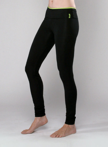 Product image waist down of a woman wearing long black leggings with a fold over waistband with apple green accent