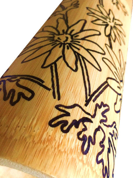 Closeup detail image of a bamboo container with black hand drawn floral designs