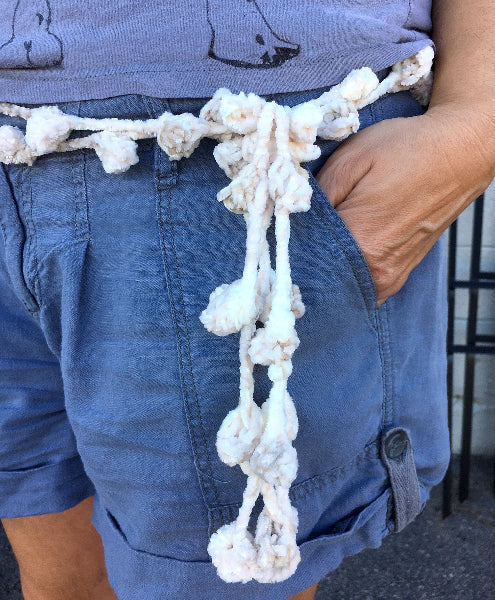 Closeup image of a woman wearing a grey t-shirt and a hand crocheted bobble chenille belt