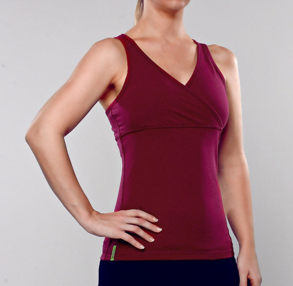 Front view image of a woman wearing a crossover wine color tank top and black yoga pants