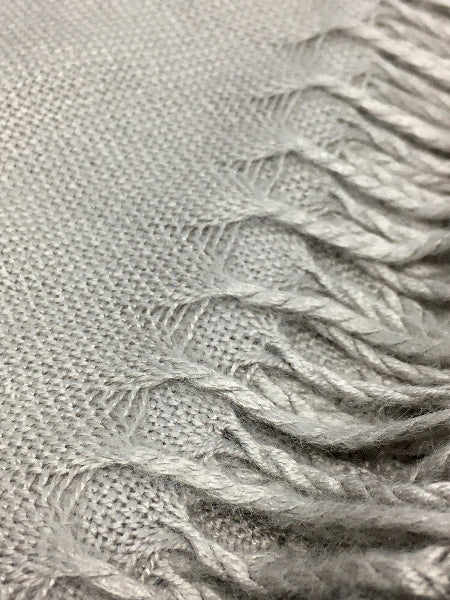 Closeup detail image of grey bamboo pashmina scarf fabric weave texture and fringe