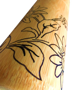 Closeup image of bamboo container with black hand drawn floral design