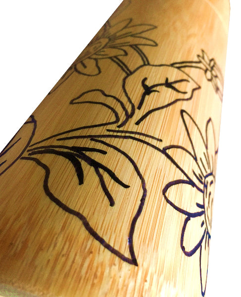 Closeup image of bamboo container with black hand drawn floral design