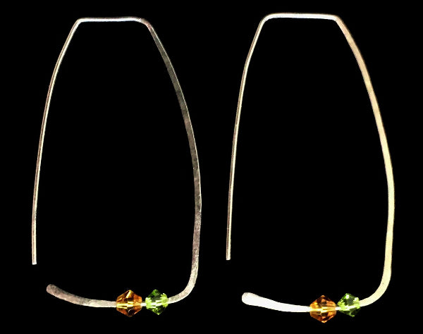 Closeup image of a pair of hammered sterling silver rectangle hoop earrings with swarovski crystals on a black background