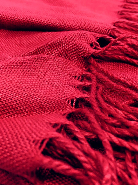 Closeup detail image of red pashmina fabric weave texture and fringe