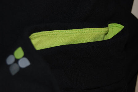 Closeup image of fold over waistband of black yoga pants with apple green contrast mesh fabric inside of the waistband